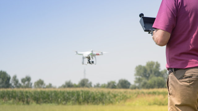 Pilot with his small drone flying outdoors, technology concepts, copy space photo