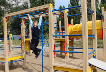 A boy, a schoolboy, a student walks on the playground in the park