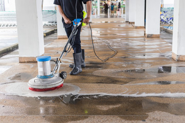 Worker cleaning sand wash exterior walkway using polishing machine and chemical or acid - obrazy, fototapety, plakaty
