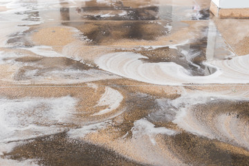 Worker cleaning sand wash exterior walkway using polishing machine and chemical or acid