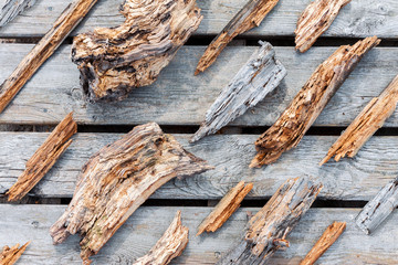 Old rotten wooden pieces and fragments well organized on wooden plank background, top view