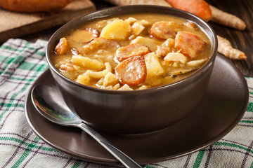Traditional Polish split pea soup with sausage, bacon and potatoes