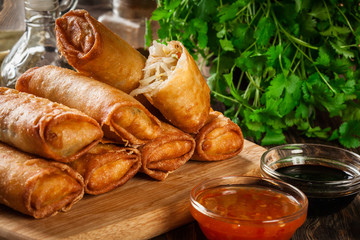Spring rolls with chicken and vegetables on chopping board