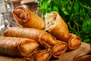 Spring rolls with chicken and vegetables on chopping board