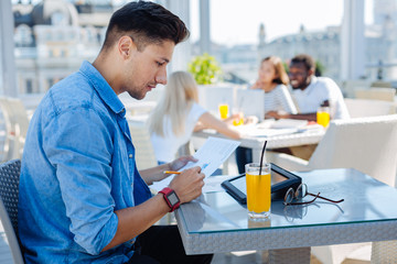 Handsome student studying in cafe