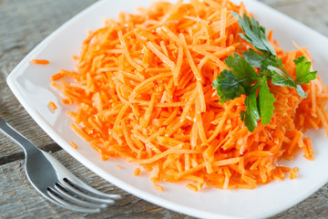 healthy carrot salad with oil and nuts.