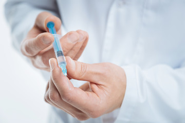 Scale up shot of medical professional checking syringe