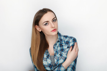 Beauty portrait of young adorable fresh looking blonde woman with hair chaos in blue plaid shirt. Emotion and facial expression concept.