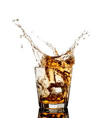 Whiskey splash out of glass isolated on white background