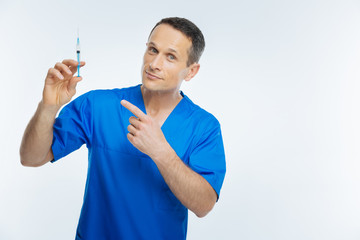 Positive minded physician pointing toward syringe