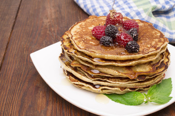 Delicious pancakes with berries and maple syrup