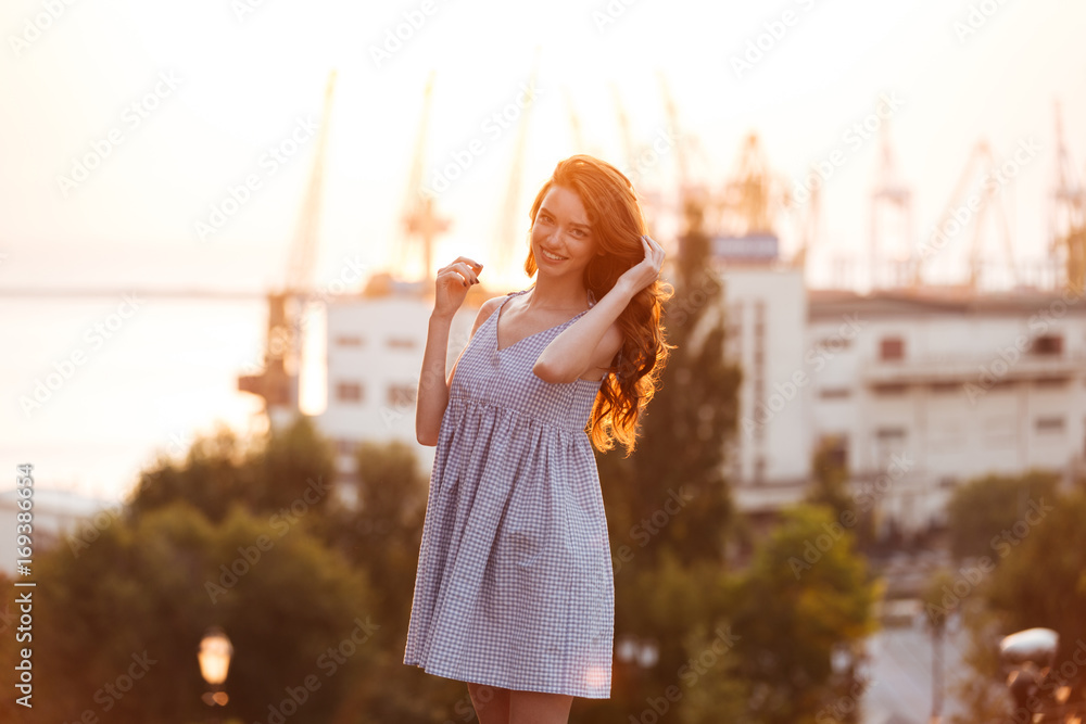 Poster Beauty Young Ginger girl in dress posing on the sunset