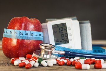 Red apple with measuring tape to measure length. Treatment of obesity and diabetes, measurement of...