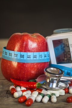 Red apple with measuring tape to measure length. Treatment of obesity and diabetes, measurement of blood pressure.
