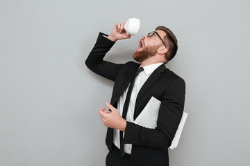 Man trying to drink last coffee drop from a cup