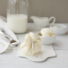 Fresh burrata cheese with dairy products. Light wooden background