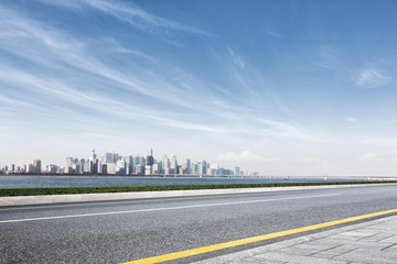 empty road with cityscape of modern city near water