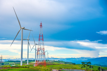 Beautiful mountain landscape with wind generators turbines and high voltage tower at Khao Kho mountain, Thailand. Renewable energy concept. 