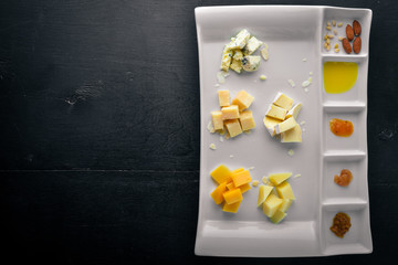 Assorted cheeses with honey. On a wooden background. Top view. Free space for text.