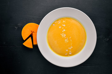 Pumpkin Soup. On a wooden background. Top view. Free space for text.