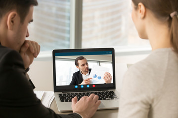 Businesspeople participate video conference looking at laptop screen during virtual meeting with investor for startup, discussing financial document online, videocall webcam app for business, close up