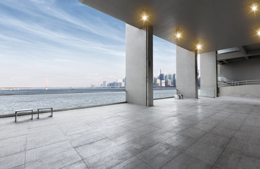empty marble floor near water with cityscape of modern city