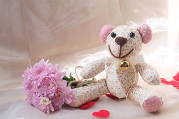 Teddy Bear and dry flower on wooden background.