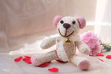 Teddy Bear and dry flower on wooden background.