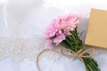 Pink flower bouquet on thin white fabric background. Wedding concept.