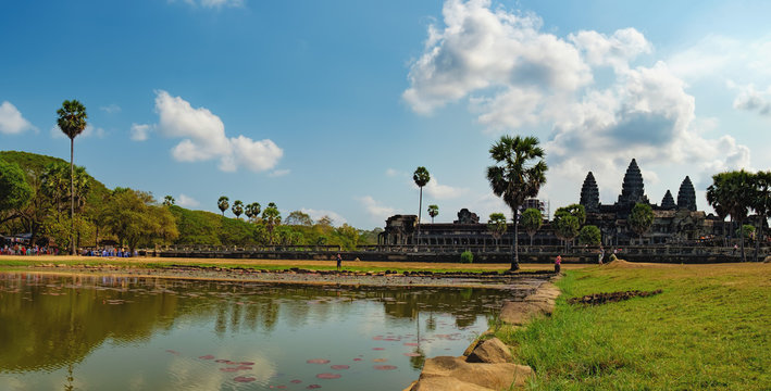 Ruins and ancient pond with Lily, Angkor Wat temple, Cambodia. The main road to Angkor Wat which runs tours. Tourists visiting the sights and taking photos.