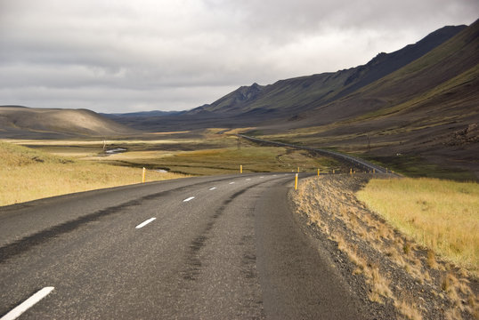 One of the few paved roads creeps into the valley between the mountains of Iceland in the Region number 2