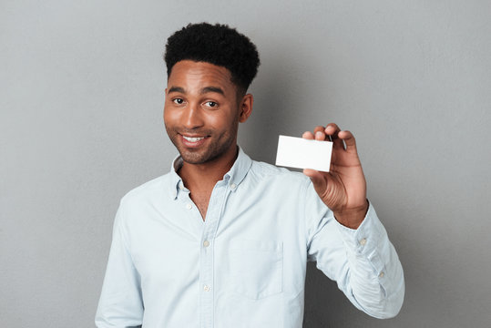 Smiling young afro american guy holding blank business card