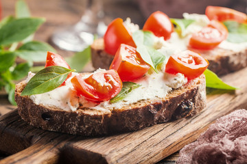 Crostini appetizers with cherry tomatoes, and cheese