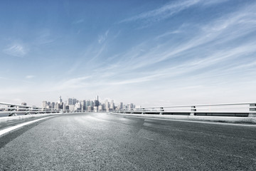 empty road with cityscape of modern city near water
