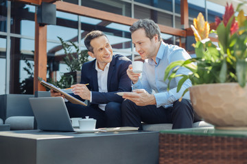 Smart successful businessman having coffee