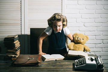 Small girl with curler in hair read book.