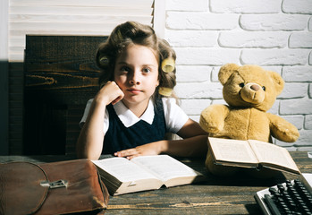 Small girl with curler in hair read book.