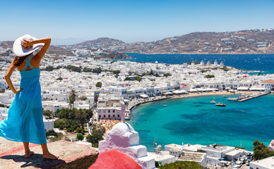 Frau mit weißem Hut schaut auf die Stadt von Mykonos, Kykladen, Griechenland