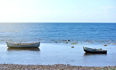 Two old wooden fishing boats on the shallows of the White Sea at low tide