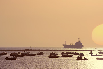 Obraz premium beautiful sunset on the sea overlooking the fishing boats