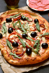 Pizza with tomato, salami and olives