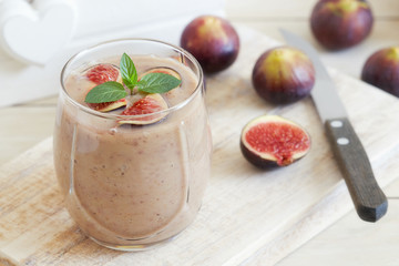 Fig smoothie served in glass with mint leaves