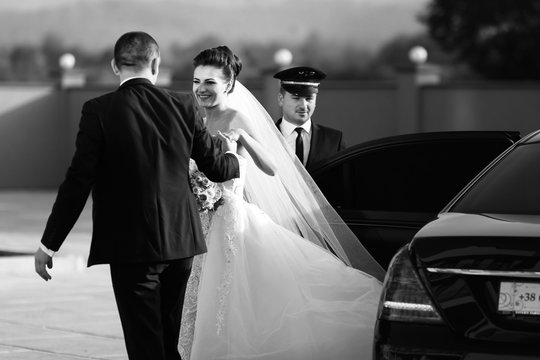 Wedding couple walks out of Mercedes car