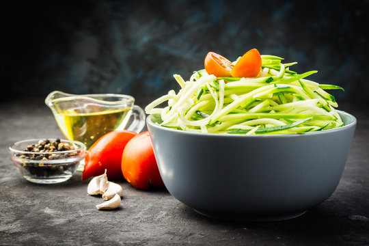 Raw ingredients for garlic, olive oil and tomato zucchini pasta. Selective focus, close up.