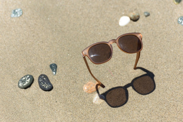 Fototapeta na wymiar Sunglasses stick out of sand