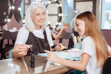 Manicurist and teenage client agreeing on nail polish