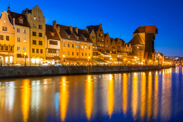 Naklejka premium Gdansk at night with historic port crane reflected in Motlawa river, Poland