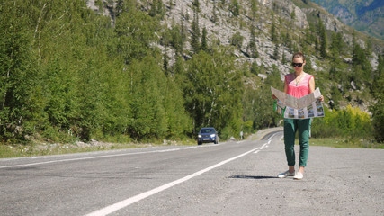 Tourist young woman wearing sunglasses chooses a travel destination on the map.