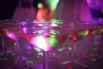Coupe de champagne avec lumières de spot de discothèque dans une soirée festive