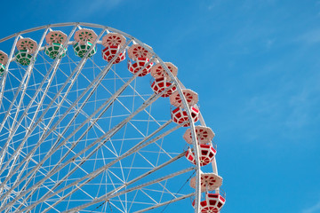 Ferris wheel on blue sky background. In the amusement Park. The weekend